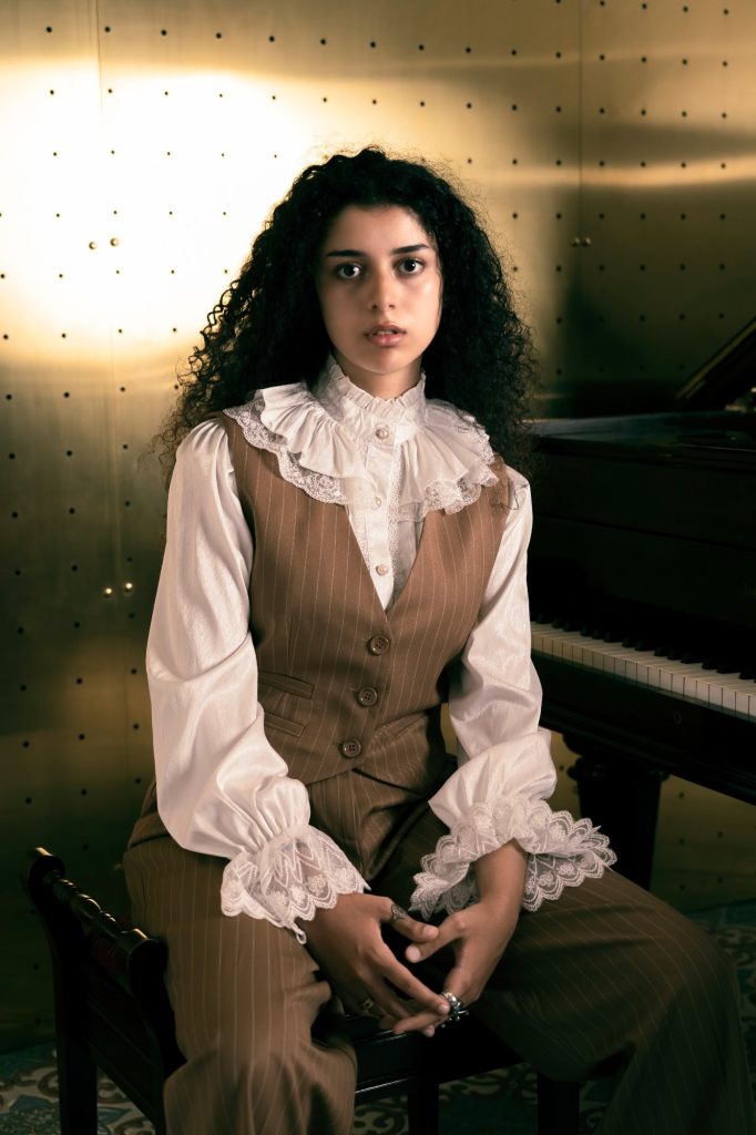 Carlotta Maestrini seduta davanti al pianoforte, camicia bianca e gilet